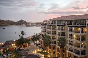 Ein mehrstöckiges Hotel mit Balkonen mit Blick auf einen Strand und das Meer.