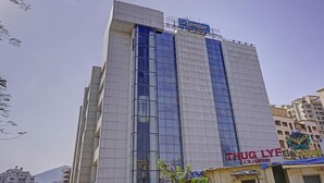 Um edifício moderno com fachada de vidro proeminente e uma placa com a inscrição 'THUG LYE Lounge' na parte inferior.