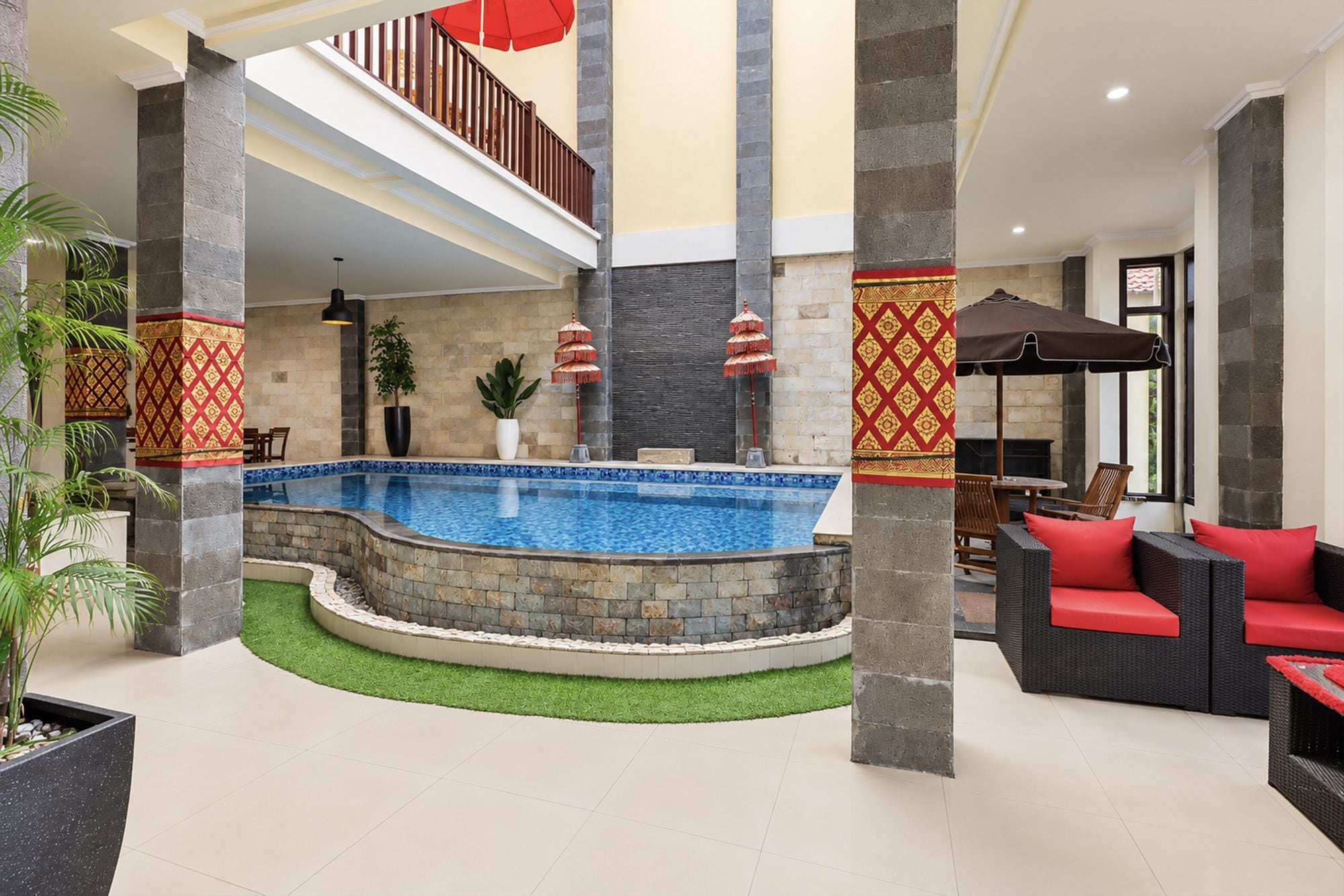 Zona de piscina con pared de piedra, sillas de descanso y una escalera.