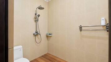 Un baño pequeño con inodoro, ducha con cabezal de ducha manual y toallero.