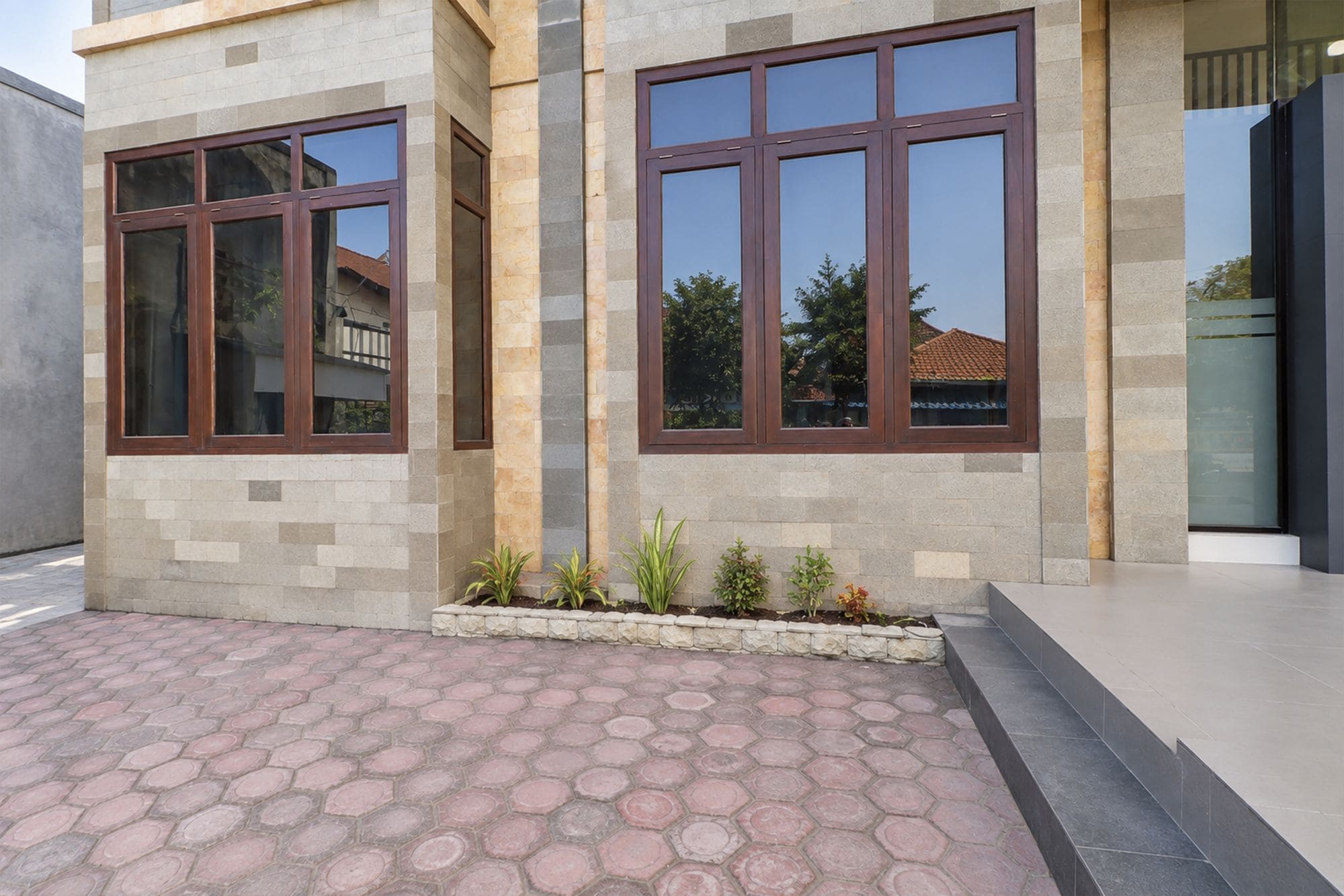 A modern building with large windows and a paved entrance area.
