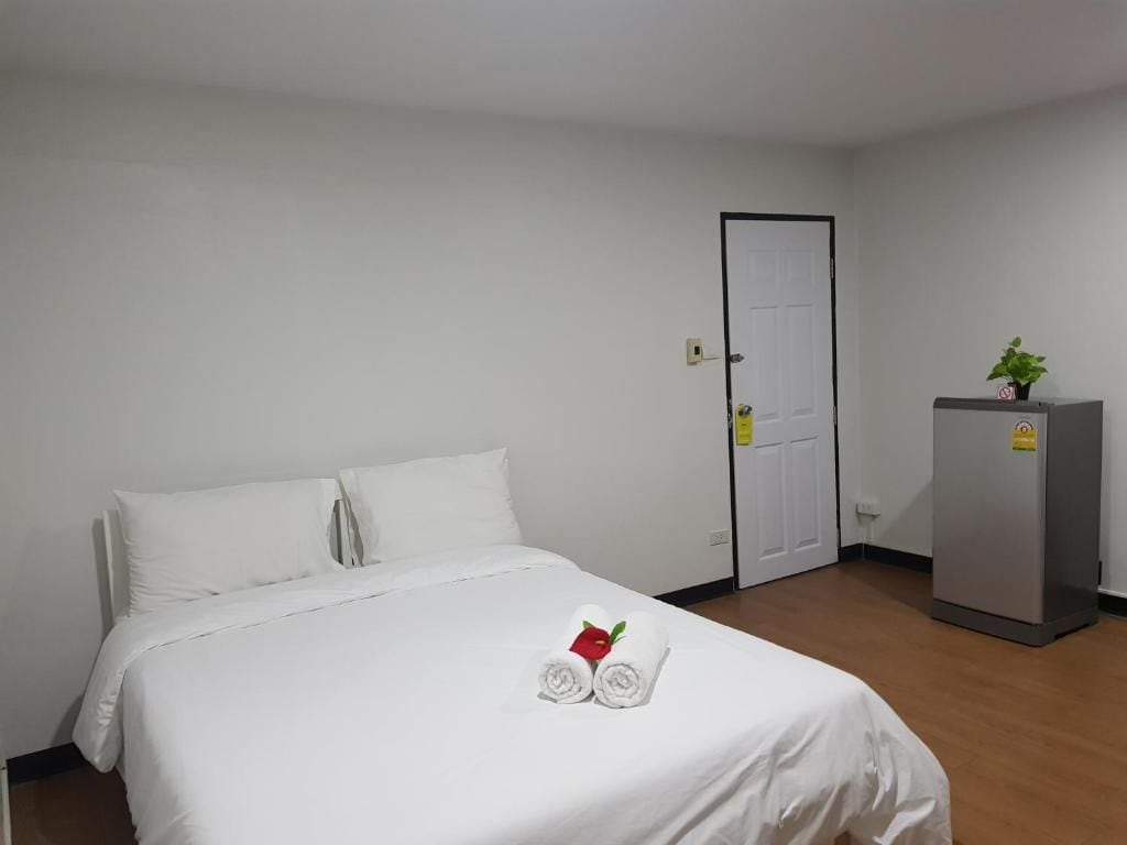 Una habitación de hotel con una cama, una puerta y un refrigerador.