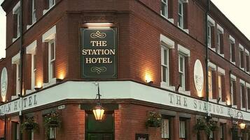 A brick building with a sign that reads 'The Station Hotel.'