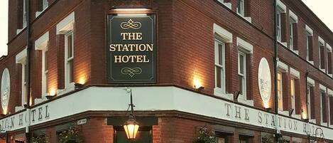 A brick building with a sign that reads 'The Station Hotel.'