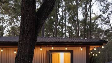 A modern building with a wooden door and a small porch area.