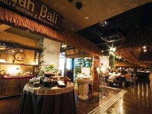 A furniture and accessory store with a tropical theme, featuring thatched roofs and wooden furniture.
