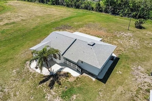 A single-story house with a sloped roof, a covered porch, and a small garden area. - Manasota Key | 4BR 3.5BA | Sleep 14 (Englewood)