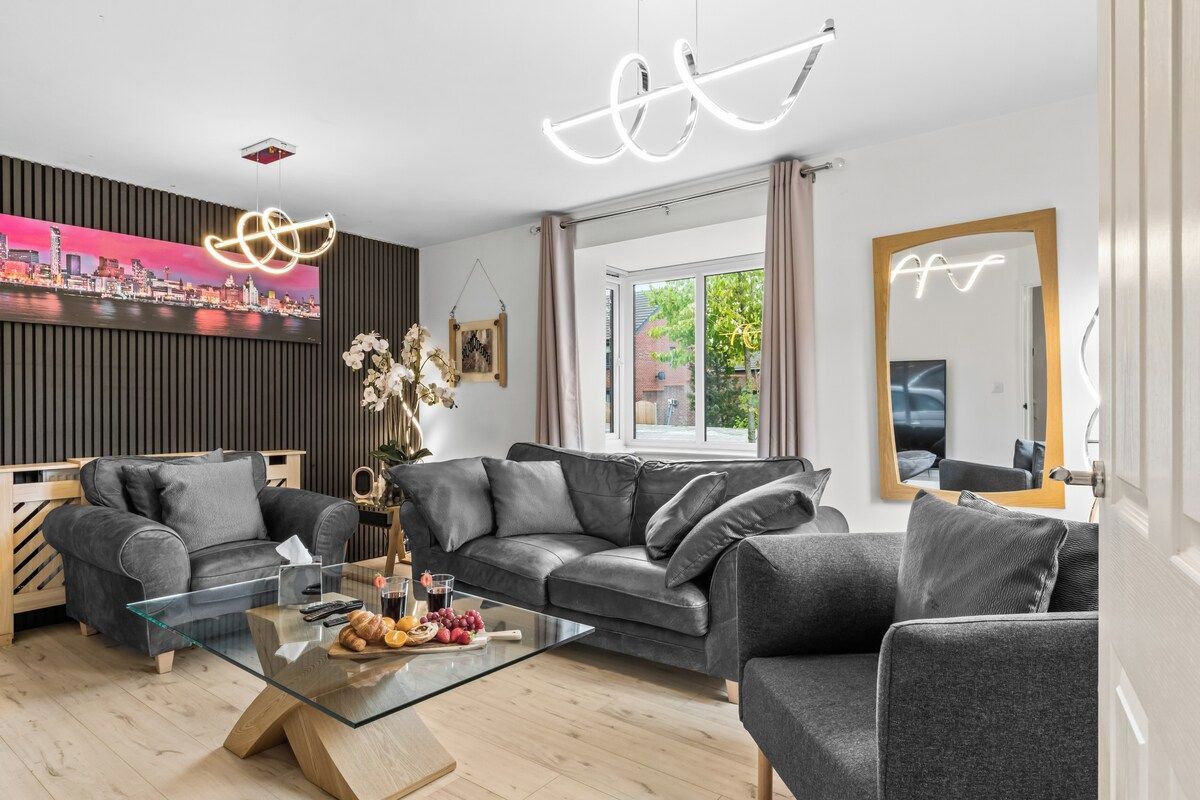 A modern living room with a glass coffee table, leather sofas, and a cityscape painting on the wall.