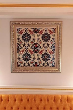 A framed artwork with a floral pattern on a wall.