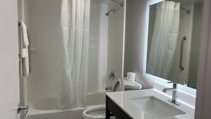 A modern bathroom with a bathtub, toilet, and sink. - Travel Inn Rockford (Rockford)
