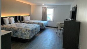 A hotel room with two beds, a desk, a chair, a TV, and a window with curtains. - Travel Inn Rockford (Rockford)