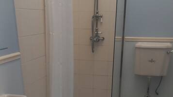 Ein Badezimmer mit Dusche, Toilette und Waschbecken.
