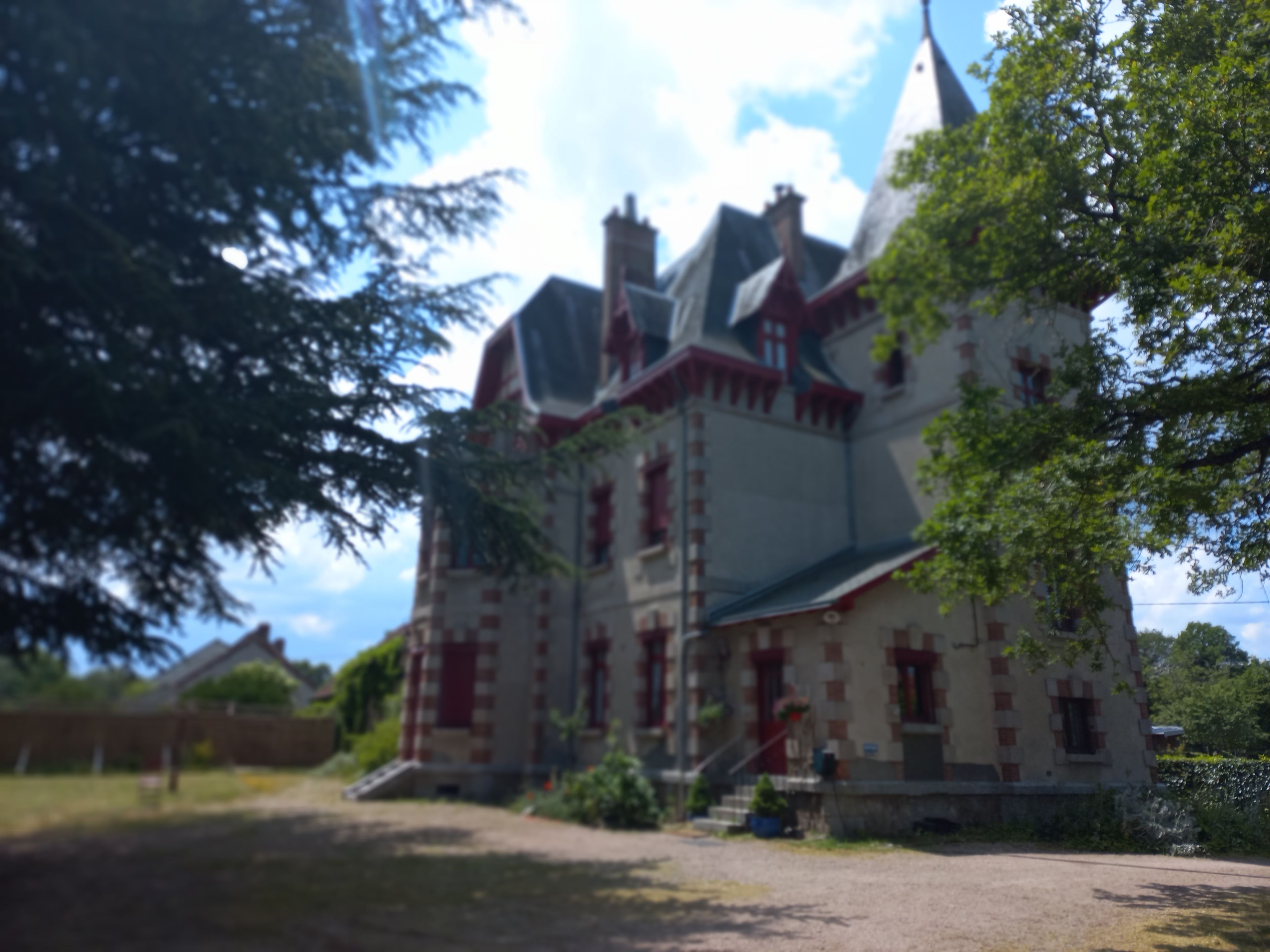 Un grand bâtiment historique, doté de nombreuses cheminées et d’une entrée imposante.