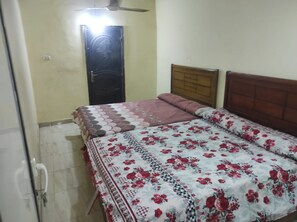 Une chambre à coucher avec un lit, une porte et un ventilateur de plafond.