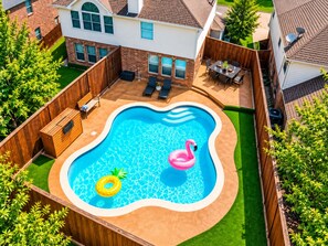 A residential backyard with a swimming pool, wooden deck, and a fenced area. - Big Groups, Game Room, BBQ, Pet Friendly, Pool (Frisco)