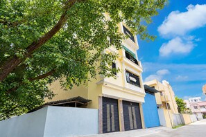 A two-story building with a yellow facade, a blue door, and a sign that reads 'Collectors.'