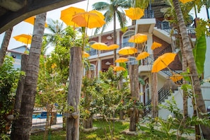Un edificio con varios balcones, algunos con mobiliario exterior y sombrillas.
