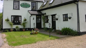 A traditional white building with a sign for 'The Six Bells Country Inn' accommodation, restaurant, and bar. - Six Bells (Bury St Edmunds)