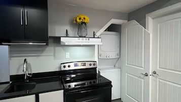 A compact kitchen with a stove, sink, and cabinets.