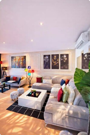A modern living room with a sofa, coffee table, and decorative lamps. - Beautiful apartment in downtown Marrakesh—3 outdoor pools, a golf course, and a terrace (Marrakech)