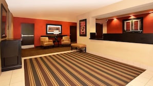 A hotel lobby with a striped carpet, a reception desk, two chairs, and a 'WELCOME' sign. - Extended Stay America Annapolis, Admiral Cochrane Drive (Annapolis)