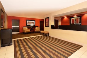 A hotel lobby with a striped carpet, a reception desk, two chairs, and a 'WELCOME' sign. - Extended Stay America Annapolis, Admiral Cochrane Drive (Annapolis)