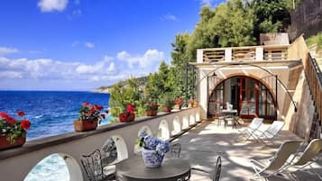 Una terrazza sul mare con zona pranzo, posti a sedere all'aperto e vista mare.