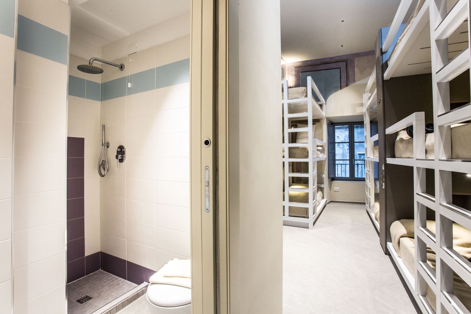 Un bagno moderno con doccia, servizi igienici e scaffali contenitori.