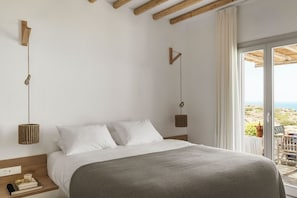 Un dormitorio con cama, mesita de noche y vistas al exterior.