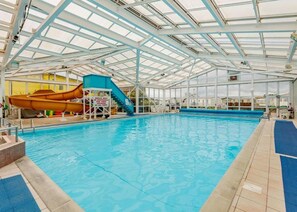 An indoor swimming pool with a slide, a diving board, and a covered area with a glass ceiling. - 3 Bedroom Seaview Cabin Sleeps 8 - Balcony & Pool (Skegness)