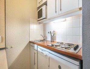A kitchen with a microwave, stove, sink, and cabinet. - Tignes Mountain Apartment Near Ski Lifts (Tignes)
