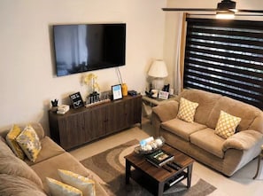 A living room with a flat-screen TV, a sofa set, a coffee table, and a cabinet. - Wonderful Ridgecrest Home (Ridgecrest)