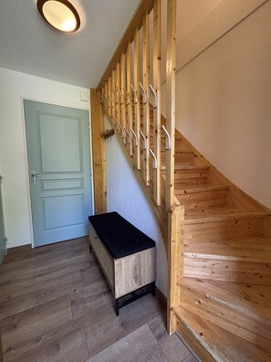 A wooden staircase with a handrail, a bench, and a door at the top. - Demi chalet avec vue sur les pistes (Dévoluy)
