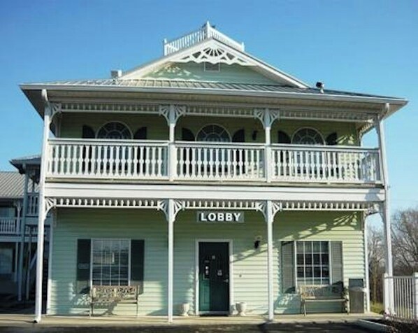 A two-story building with a balcony on the upper floor, a sign reading 'LOBBY' above the entrance, and a small porch area. - Key West Inn Cookeville (Cookeville)