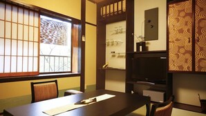 A traditional Japanese room with tatami flooring, a low table, and sliding doors. - Kinosaki Tenboen (Toyooka)