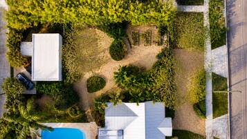 An aerial view of a residential property with a swimming pool, a garage, and a driveway.