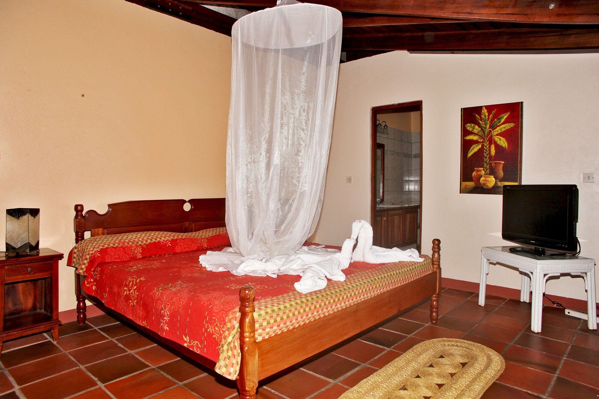 A room with a wooden bed, a television, and a painting on the wall.