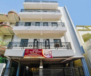 A multi-story hotel with balconies and a prominent sign advertising the Blue Velvet Hotel. - Classic Hotel Blue Velvet (Danapur)