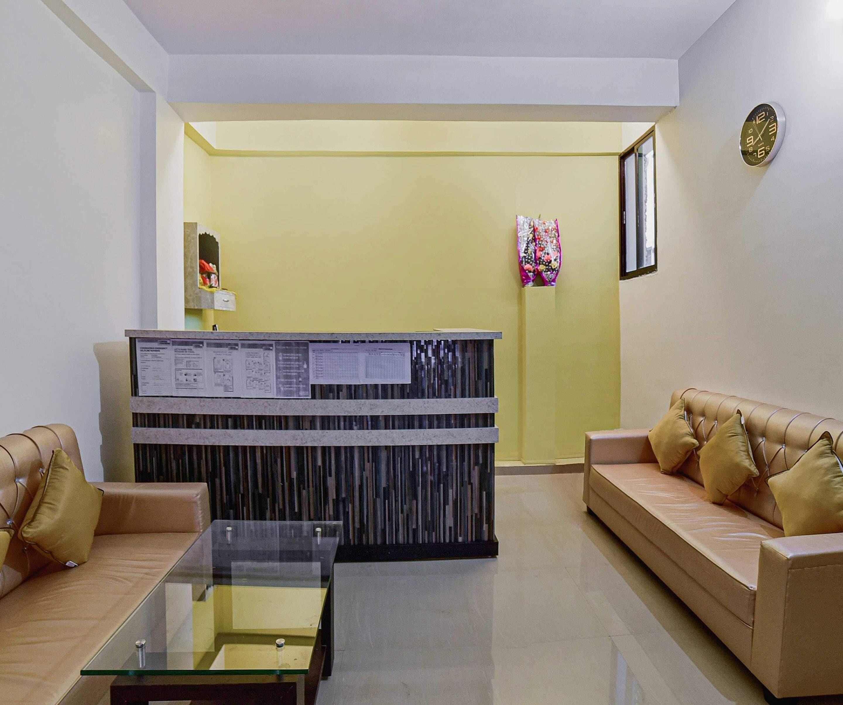 A reception area with a reception desk, two sofas, a glass coffee table, and a wall clock.