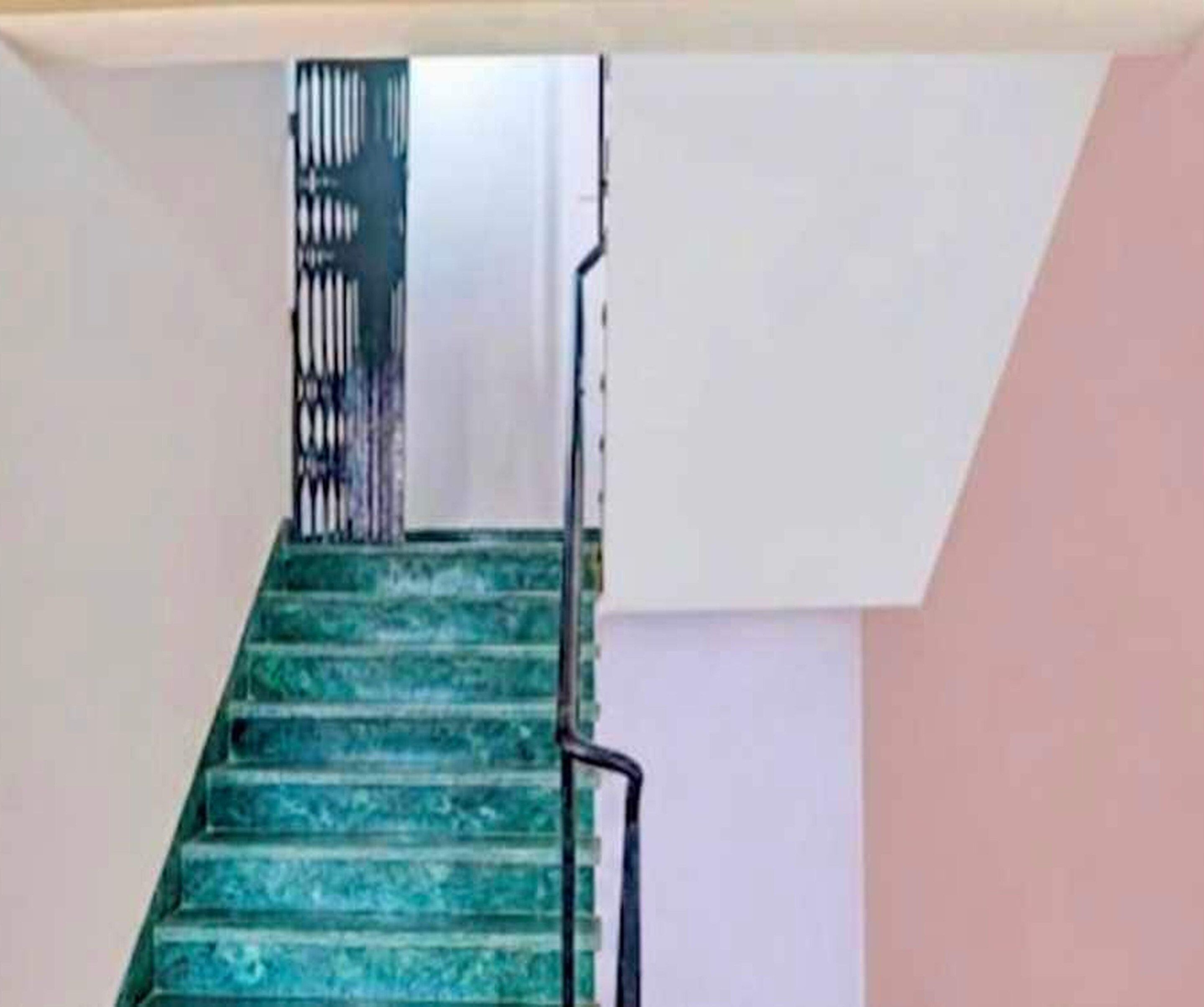 A staircase with a metal railing and a handrail.