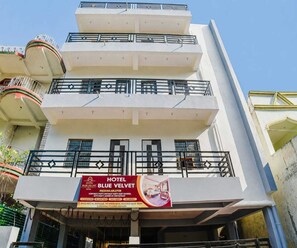 A multi-story building with balconies and a sign for Hotel Blue Velvet.