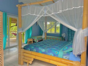 Quarto com cama, ventilador e janela.
