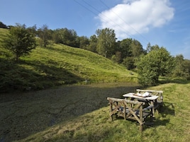 A picnic table set up on a grassy hill with a clear sky above.