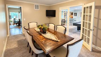 A dining room with a wooden table, six chairs, and a decorative centerpiece.