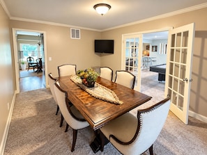 Comedor con mesa de madera, seis sillas y un centro decorativo.