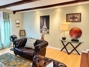 A living room with a leather sofa, a glass coffee table, and a lamp. - Spacious 7-bedroom home with heated pool and Jaccuzzi (Oklahoma City)