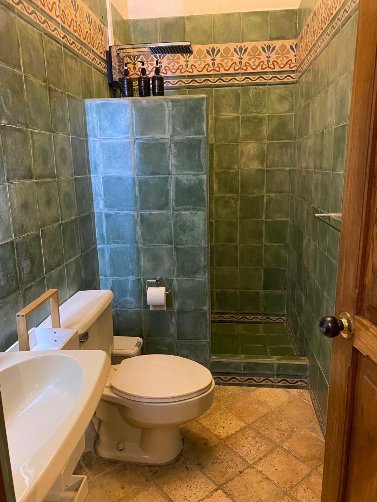 Un baño con inodoro, lavamanos y zona de ducha.