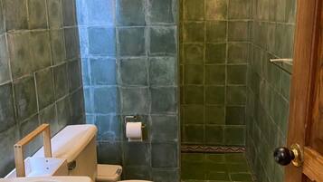 Un baño con inodoro, lavamanos y zona de ducha.