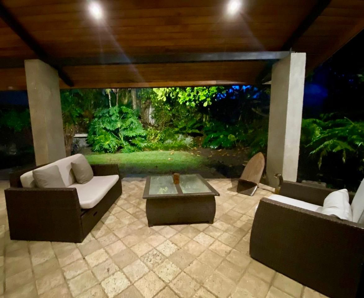 Un espace extérieur aménagé avec un canapé, des fauteuils et une table basse.