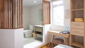 Un baño moderno con tocador de madera, inodoro y zona de ducha.